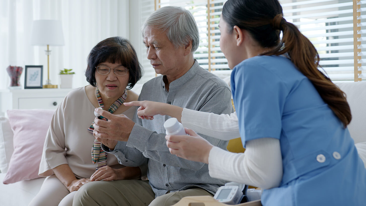 Female nurse explaining medication instructions to an older man and woman